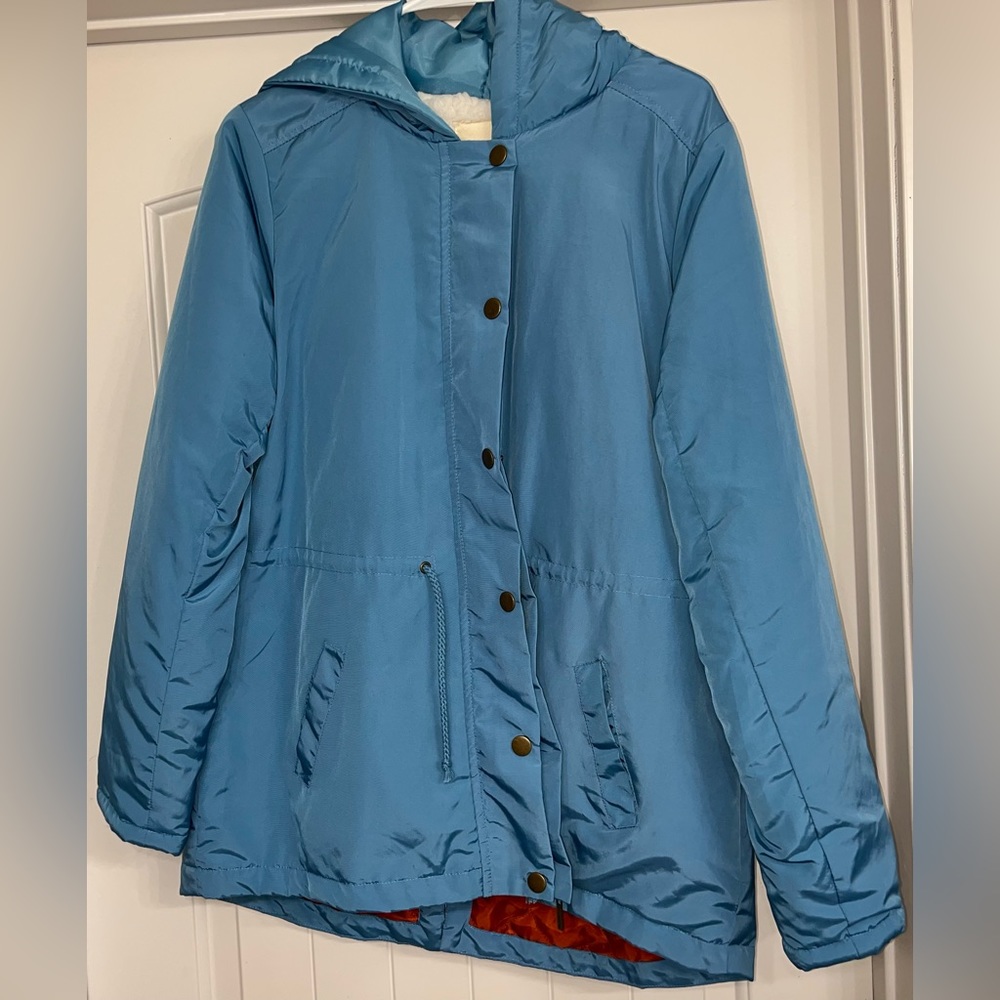 Blue Jacket sherpa on inside through arm, orange inside